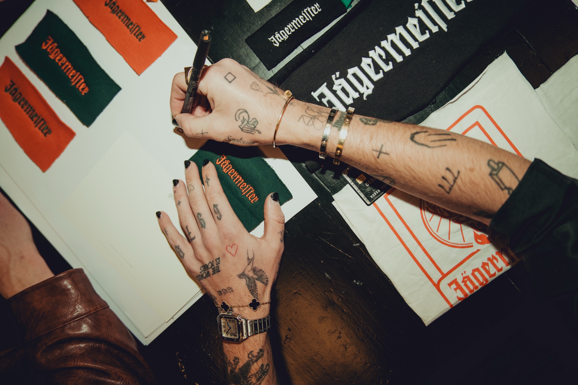 Designers' hands reviewing Jägermeister fabric swatches