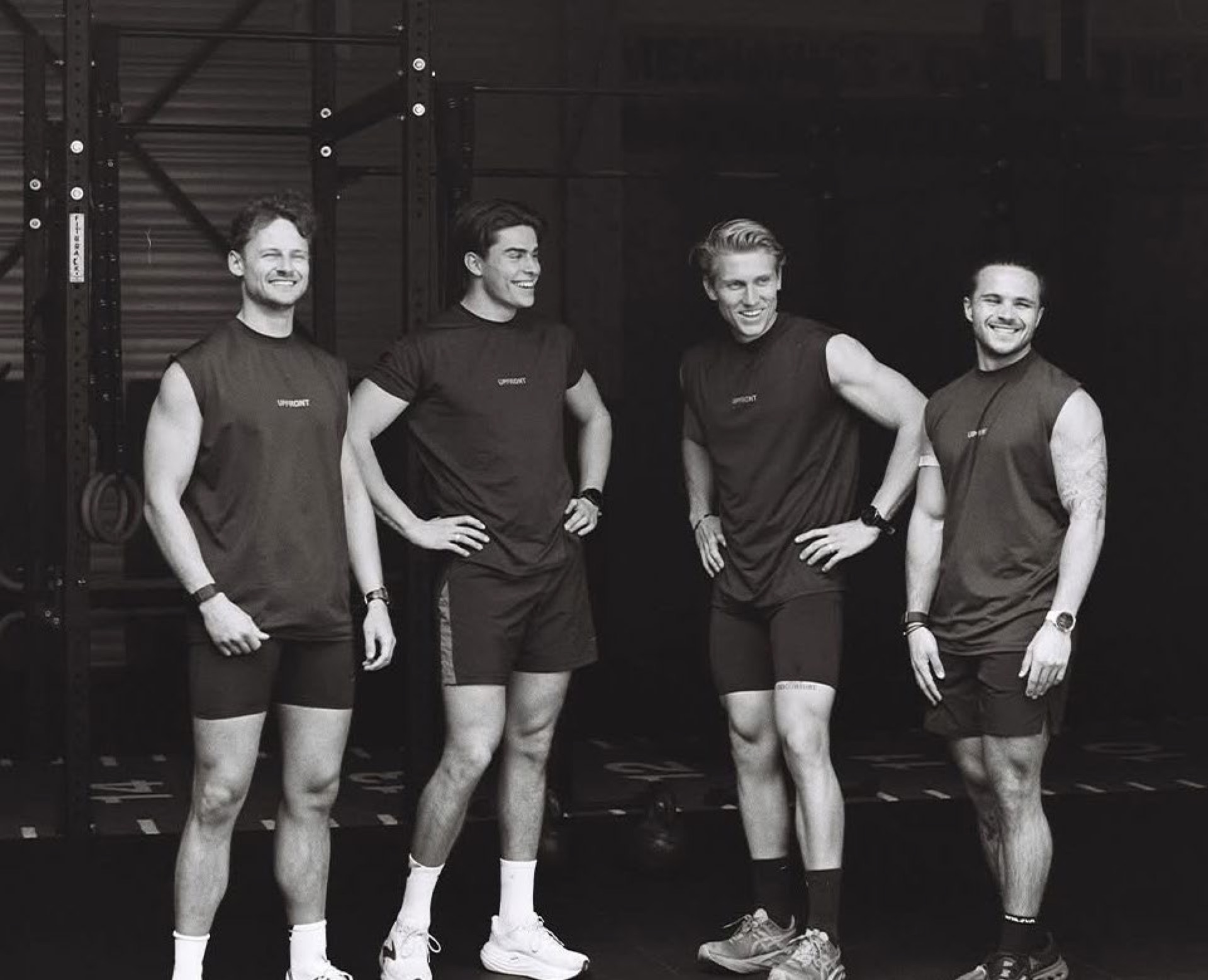 Group of four athletes in matching Upfront tanks — B&W